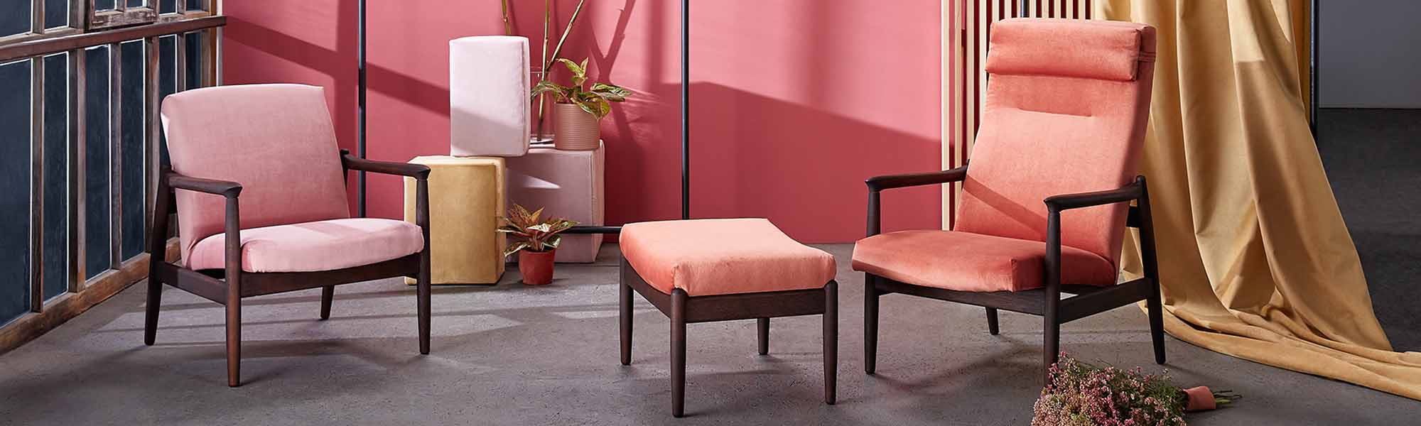 Designer wooden chairs and ottoman in pink fabric in the living room