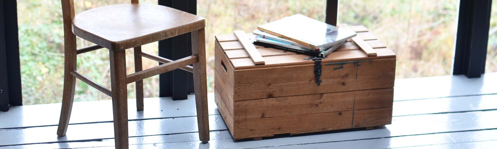 A beautiful wooden chest in the interior of a room in front of a large window