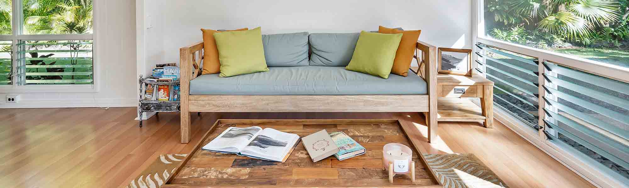 A wooden bed with a soft mattress and cushions on the terrace