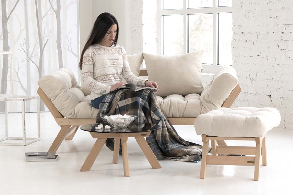 A folding futon sofa on which a pretty girl is sitting