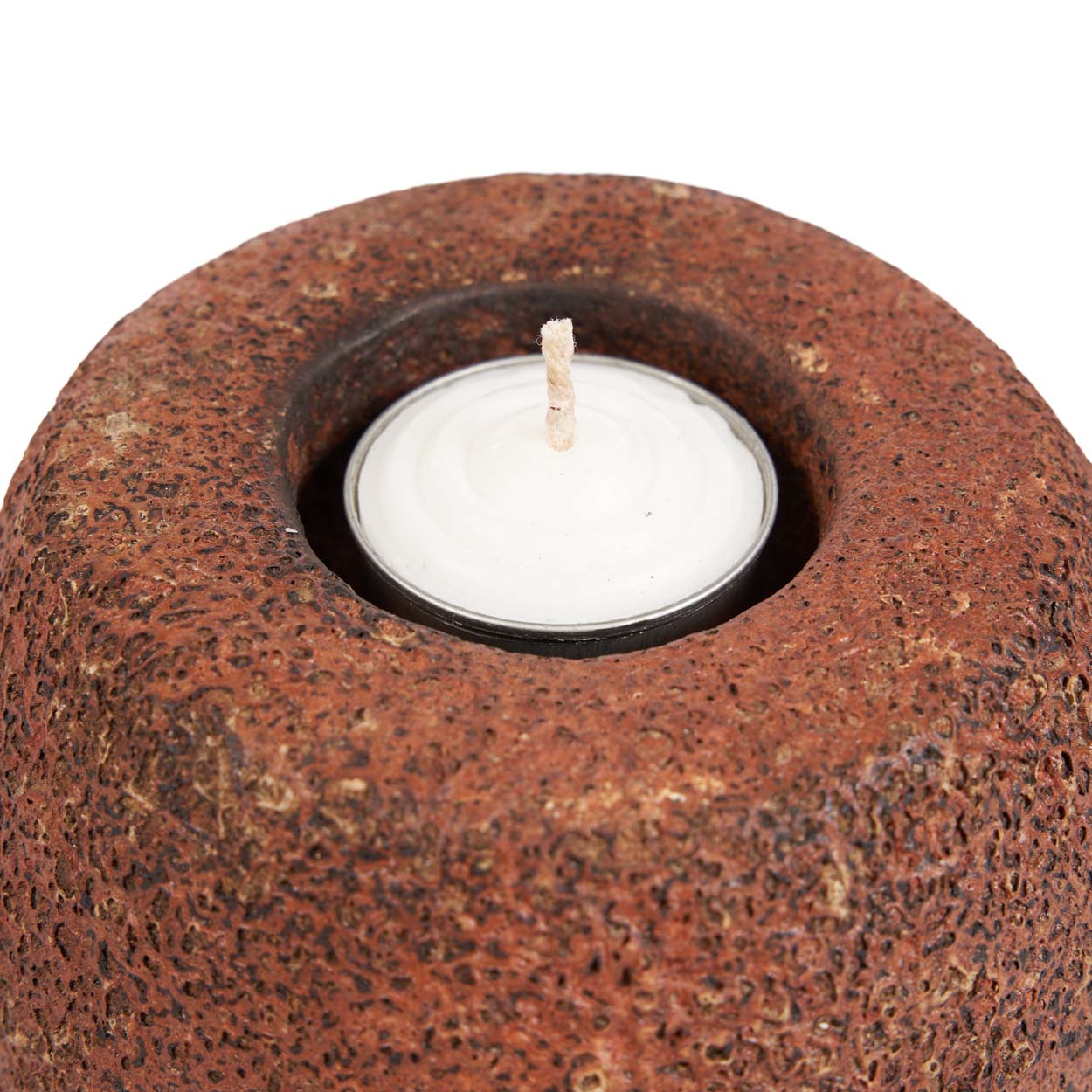 Terracotta candle holder with a white candle inside on a white background