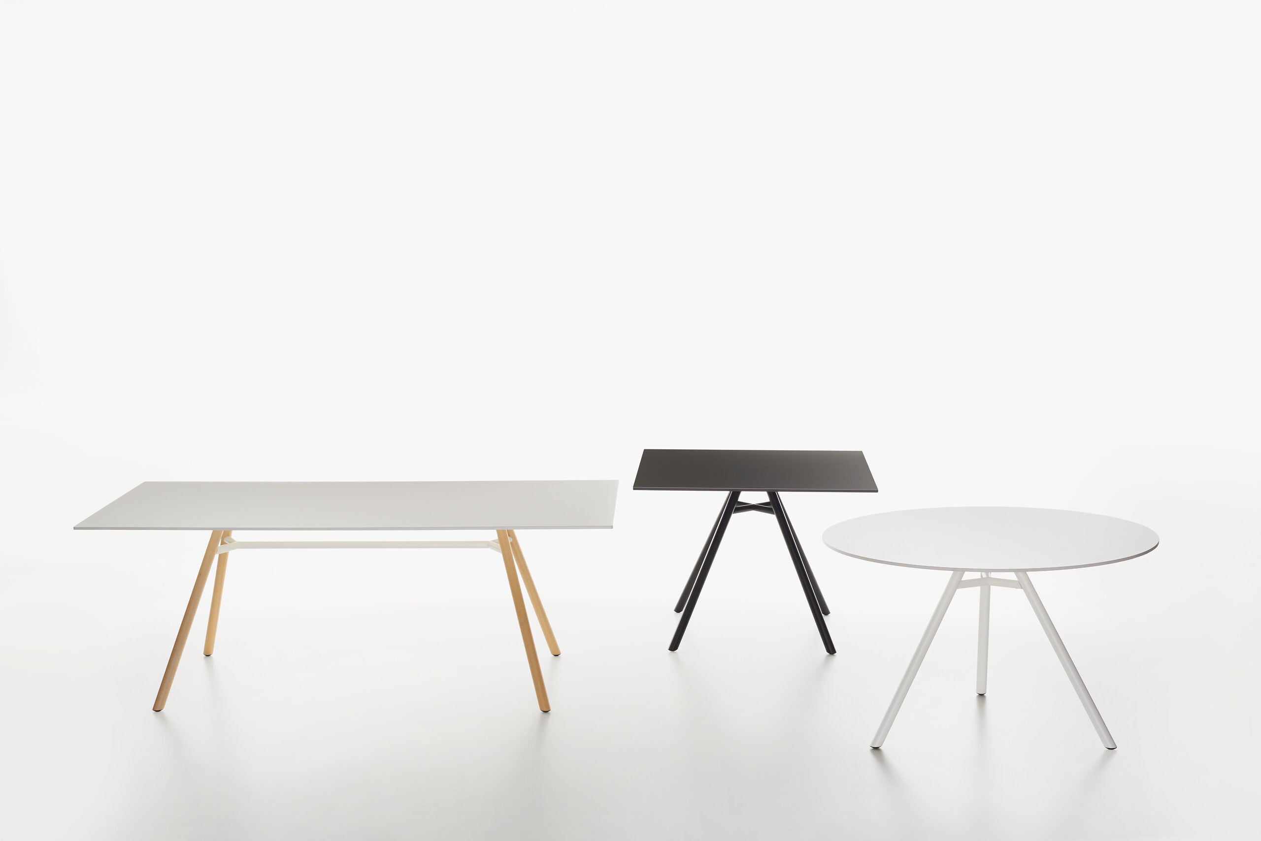 Three modern minimalist MART tables on a seamless white studio background.