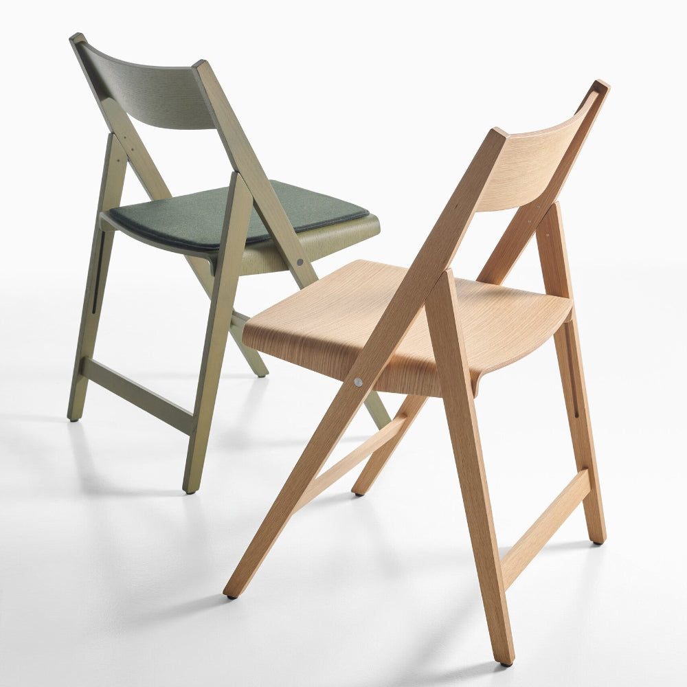 Two THEO chairs, one green and one natural, on a white background