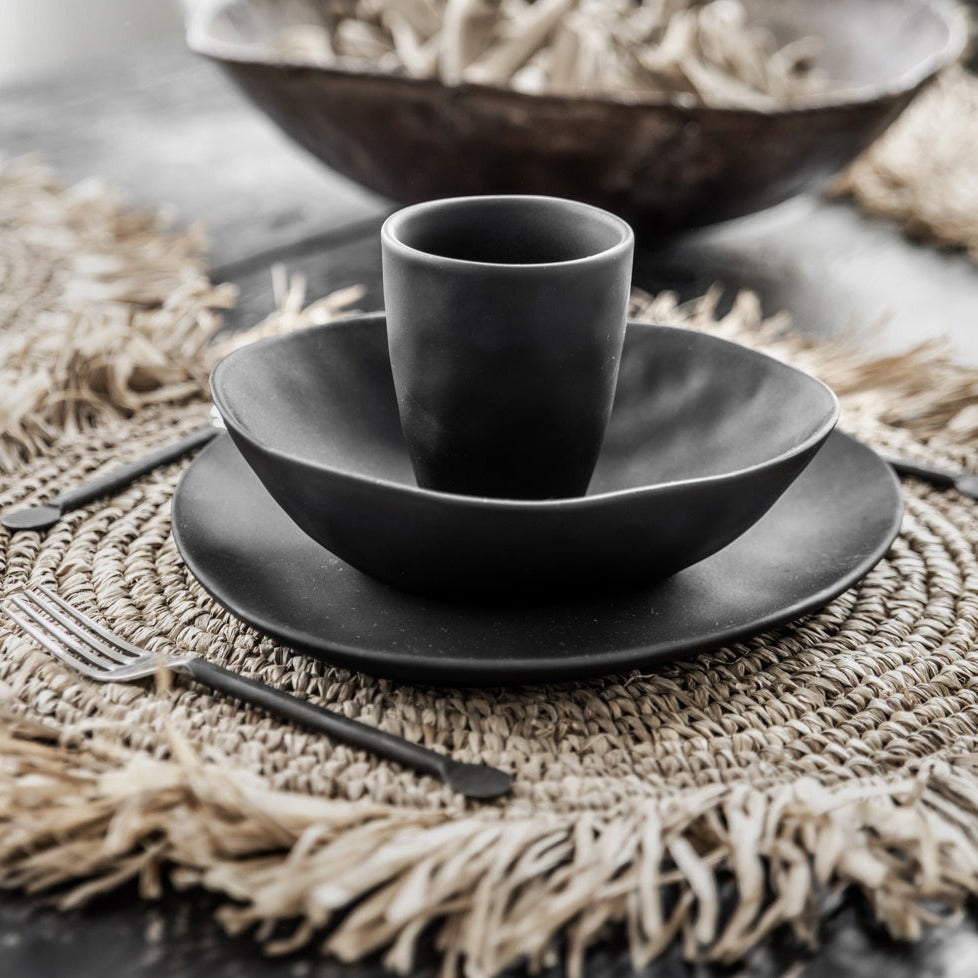 THE FRINGE RAFFIA Placemat Round Natural side view with black cup